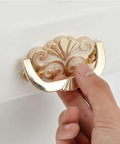 Antique Gold Concealed Flat Pull Cabinet Handles Set Of 2 No Drill Required, close-up of hand holding ornate pull with cream enamel accent