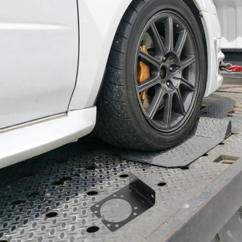 Heavy Duty Iron Trailer Wiring Connector Mounting Bracket Black Set Of 2 For Secure Harness And Towing Wiring, Durable Iron Construction, Safety Focused Design To Prevent Disconnections And Vibration. black iron bracket on tow platform beside car wheel