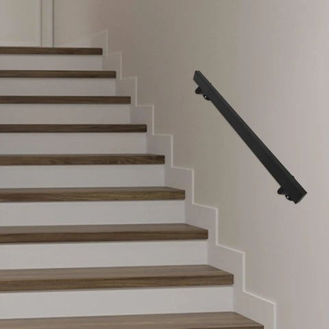 Rock Solid Four Foot Flush Handrail Wall Mount Stair Railing With Sleek Matte Black Finish and Heavy Duty Stainless Steel Design mounted on white stairs.