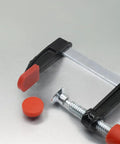 Heavy Duty Woodworking F Clamps With No Sweat Quick Adjust And Badass Multi Function Grip For Precision Project Assembly. Close-up of clamp and red pad.