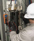Technician using Auto Ranging TRMS Digital Multimeter MM420 Pro Grade With 600V AC DC Voltage in electrical panel.