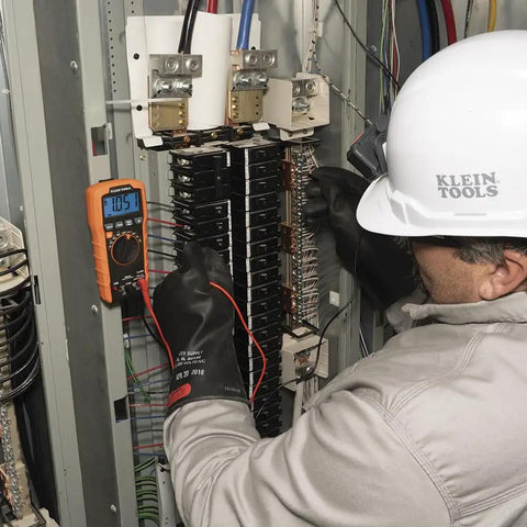 Technician using Auto Ranging TRMS Digital Multimeter MM420 Pro Grade With 600V AC DC Voltage in electrical panel.