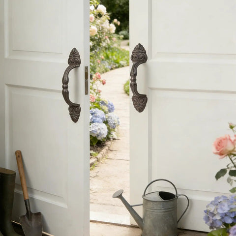 Vintage Cast Iron Door Handle Set 2 Pack Built Tough For Farmhouse Style Cabinet Pulls And Sliding Doors Fence Gates Cupboards Durable Antique Brown Finish shown on double doors in a garden setting.
