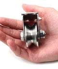 Stainless Steel 2 Inch Sliding Gate V Groove Roller Bearings Pulley Wheels With Bracket held in hand, close-up view