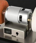 Close-up of Badass Compact Bench Grinder With Dual Wheel Grit Setup showing steel body, motor housing, and toggle switch.