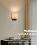 AuroraSpher Indoor Hardwired Modern Milky White Acrylic Black Wall Sconce, softly illuminated on a wall, enhancing the room's ambiance.