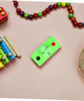 Mini Solar Powered DC Motor For Science Experiments And Hands On DIY Projects on a desk with colorful beads