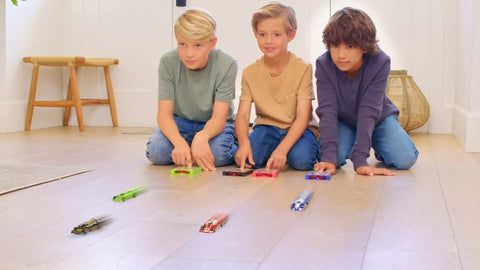 Boys racing Pocket Size Racecar Launcher With Real Rubber Tires For High Speed Racing on wooden floor indoors, toys in motion