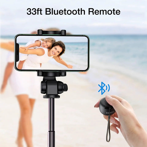 Person holding a Bluetooth remote with smartphone on tripod at the beach. Mini Portable Bluetooth Speaker 5.0 not visible.