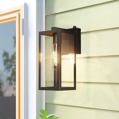 Dusk To Dawn Photocell Sensor Black Outdoor Wall Lantern With Clear Glass Shade on house exterior, bulb shining in frame