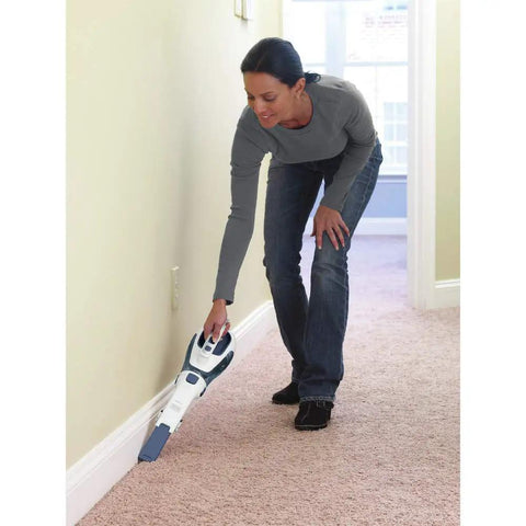 Person using Cordless Lithium Hand Vacuum Dustbuster for Quick Cleanups Across Cars, Furniture, and Carpets on carpeted floor