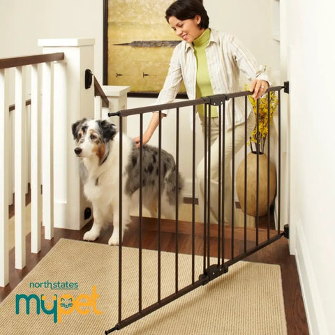 Woman using Bulletproof Hardware Mounted Walk Thru Pet Gate 31 Inches Tall Fits 28 To 48 Inch Doorways to secure a dog indoors.