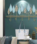 Rock-Solid Wall Mount Coat Hanger Hook Holder, Heavy-Duty Multi-Purpose Key Rack Organizer With Adjustable Hooks For Entryway, Bathroom, Bedroom And Office Storage, Tough Solution To Organize Coats Keys Umbrellas Hats Towels And Daily Gear with decorative leaf design and handbag.