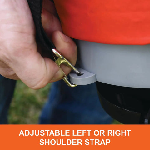 Close-up of adjustable shoulder strap on 25 lb handheld bag seeder spreader with waterproof bag and enclosed gears in bright orange.
