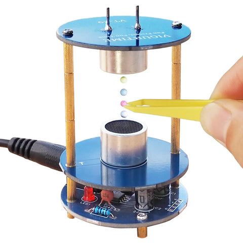 Ultrasonic Levitator Solder Practice Kit showing levitating beads with yellow tweezers, 12V adapter visible.
