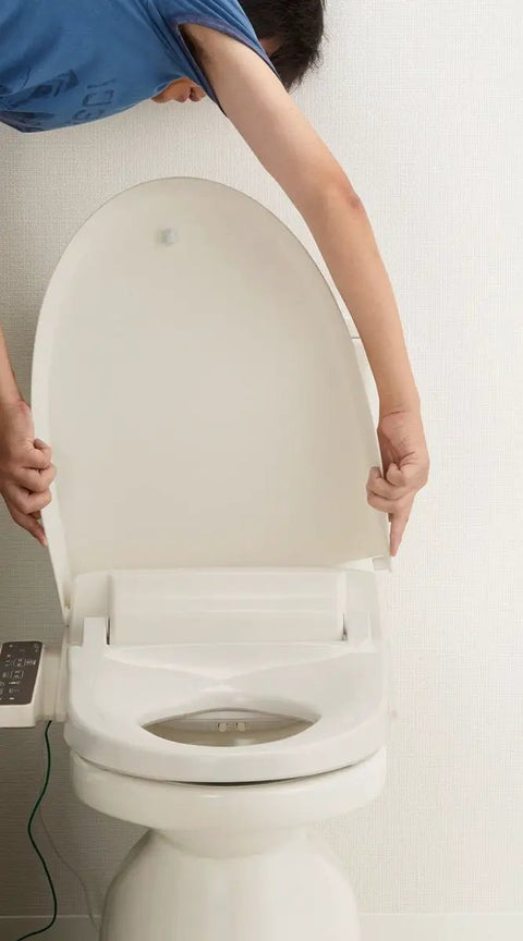 Person lifting the lid of a Straight Up Comfort Heated Bidet Toilet Seat in durable off-white design.