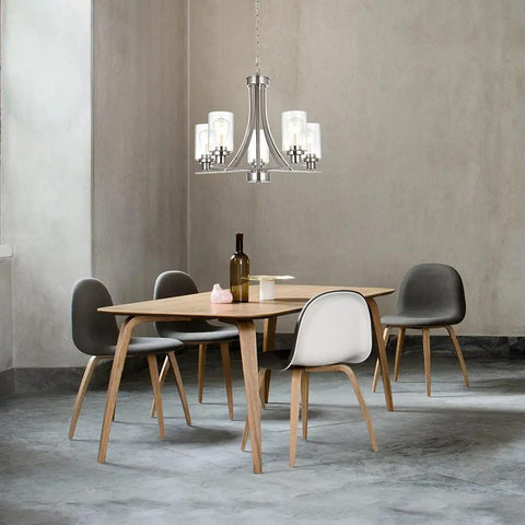 Traditional 5 Light Chandelier In Brushed Nickel With Clear Glass Shades over modern dining table with gray chairs