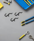 150 Pcs Plastic Pegboard Hooks For Tool Storage And Small Kitchen Supplies, Heavy Duty Repositionable Pegboard Hangers With Easy Assembly, Ideal For Retail Displays And Garage Organization, Studio Gear Black on gray surface