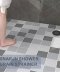 Heavy Duty Matte Black Snap In Shower Drain Cover Slick Round Stainless Steel Grid For Modern Bathrooms in a tiled shower.