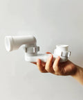 Low Profile Shower Drain Trap Kit 1.5 Inch For Small Bathrooms Flat PVC Waste Pipe System held in a hand