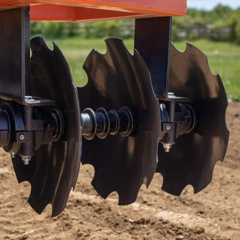Close-up of 16-inch notched discs on a 5ft Notched Disc Harrow Attachment for Cat 1 Tractors, 3-point implement on soil