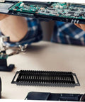 Circuit Board Storage Stand Pack Of 4 ESD Rack Anti Static Shelf PCB Holder For Display And Safe Storage Of Printed Circuit Boards On Workbench Or Cabinet Durable And DIY Friendly image showing a black anti-static PCB rack on a workbench, with a technician handling a circuit board.