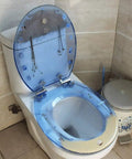 Hella Durable Round Resin Toilet Seat With Crystal Clear Aquarium Vibe And Smooth Sit Ergonomic Comfort Featuring Rock Solid Metal Hinges For A Top Tier Bathroom Setup That Looks Absolutely Sick, showing transparent seat with smooth blue finish.