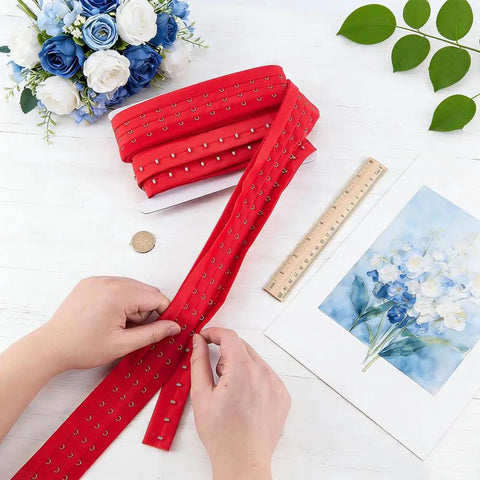 Rock Solid Three Inch 3 Row Hook And Eye Bra Extender Tape In Vibrant Red for wedding dress adjustments on a table.