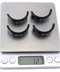 Four black Aluminum Alloy Handlebar Shims 31.8mm to 35mm on scale displaying 12g