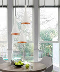 White 7.25-Inch Mini Pendant Light With Gold-Interior Metal Shade above dining nook table, adjustable cords visible