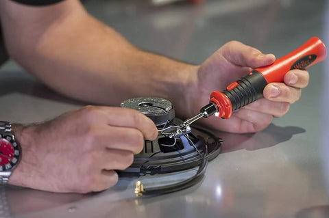 Using cordless soldering iron with rechargeable lithium ion battery and ergonomic handle for on the go soldering with LED targeting light.