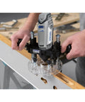 Dremel 335-01 plunger router attachment, front view, gray/black plastic with clear base mounted on wooden board.