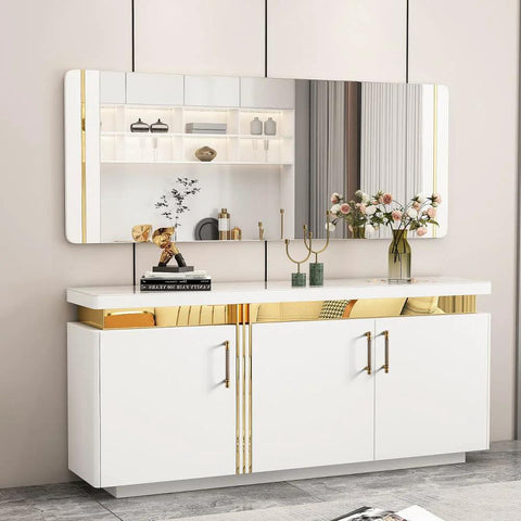 Modern white sideboard with sleek gold accents and decorative items including books and vases in a stylish living room setting.