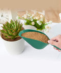 Person using All-Purpose Plastic Garden Soil Scoop Shovel, Lightweight Portable Digging Tool for Easy Planting beside a potted plant
