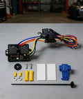 Digital Thermostatic Fan Switch Kit for 12V Motors and EVs Adjustable Temperature Activation 40C to 120C with Prewired Harness Relay Sensor and Plug N Play Setup components displayed on a table.