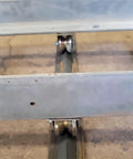 Close-up view of 2 Inch V Groove Wheels Built Like A Tank Using Bombproof 1045 Steel, rolling on a heavy duty track.