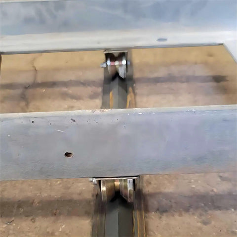Close-up view of 2 Inch V Groove Wheels Built Like A Tank Using Bombproof 1045 Steel, rolling on a heavy duty track.
