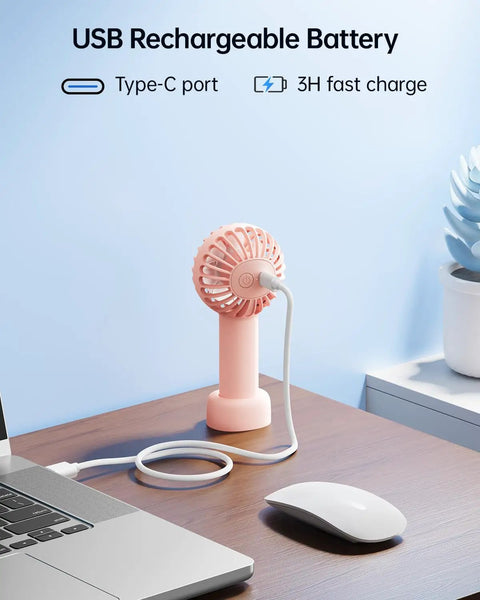 Mini Portable USB Rechargeable Handheld Fan, 3 Speeds, Cute Pink Travel Companion charging via laptop Type-C port on desk.