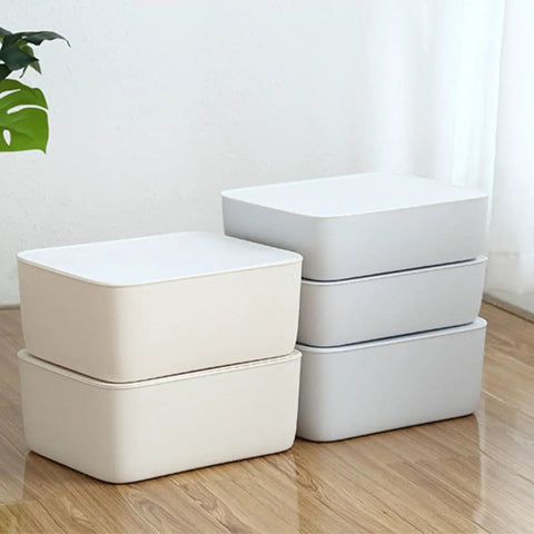 Stackable White Plastic Drawer Organizers For Bras Socks And Underwear Open Top Storage Bins neatly stacked on a wooden floor.