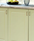 Antique Brass 3 Inch Cabinet Pulls Set on cream kitchen cupboard doors, showcasing solid zinc alloy handles, 30 Pack.