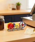 3D Printed Tourbillon Escapement Clock Model With Manual Assembly And Wind Up Movement on desk beside jar