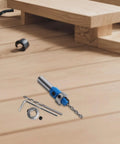 Pro Grade Adjustable Wood Countersink Drill Bit With Tungsten Steel Depth Limiter next to additional drill accessories on a wooden surface.