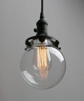 Three Light Industrial Cluster Pendant Ceiling Fixture With 5.9 Inch Clear Globe Shades In Black Finish showing a single globe
