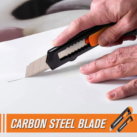 Side view of retractable utility knife with orange grip and carbon steel blade cutting cardboard.