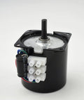 CHANCS 60KTYZ gear motor with black housing and metal gearbox, protruding shaft, white 4-pin connectors and capacitor.