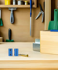 Two Ten Piece Blue Aluminum Motor Shaft Coupling Connectors 6mm with installation tool on wooden workbench.
