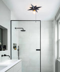 Black Star Flush Mount Ceiling Light With Pull Chain On Off Switch in modern bathroom setting, mid-century style, black finish.