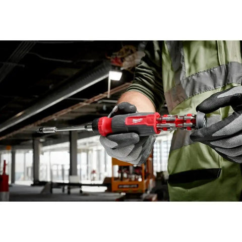 Person using 27-In-1 Screwdriver Set With M-BIT RCHT, Red Handle, 48-22-2904, in an industrial setting.