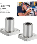 Front view: two plated flange linear bearings with square four-hole mounting flanges for printer rods.
