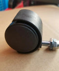 Close-up of a black universal heater caster wheel with metal mounting bolt and nut
